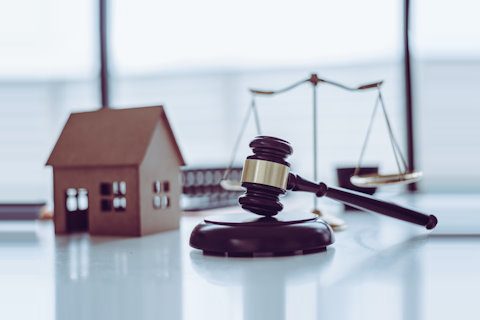 illustration contentieux locatif copropriété une maison et le marteau de la justice